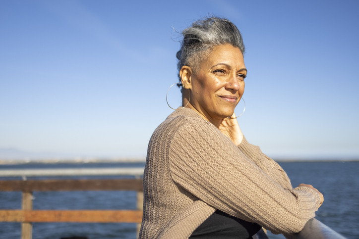 Mature woman looking out at ocean, smiling