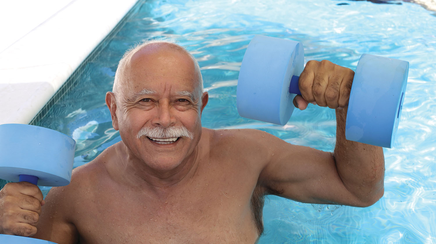 photo d'un homme âgé tenant des haltères dans une piscine