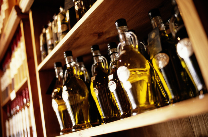 Bottles of olive oil on shop shelf, close-up