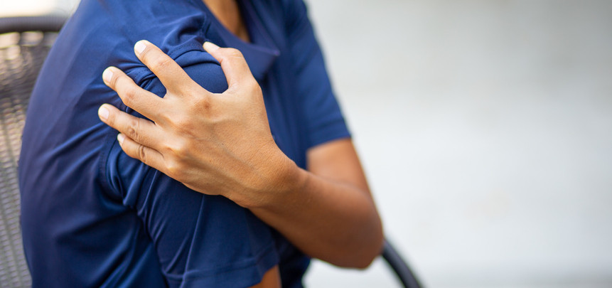 Woman holding her hurt shoulder