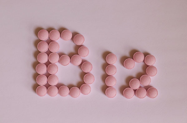 photo of pink vitamin pills arranged to form the letter B and the digits 1 and 2