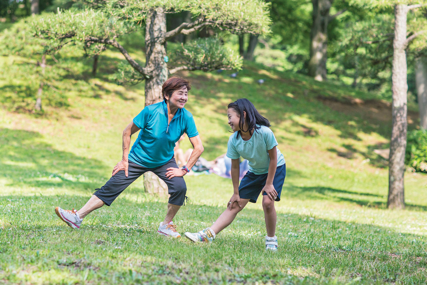 photo of a man and a woman exercising outdoors in a park