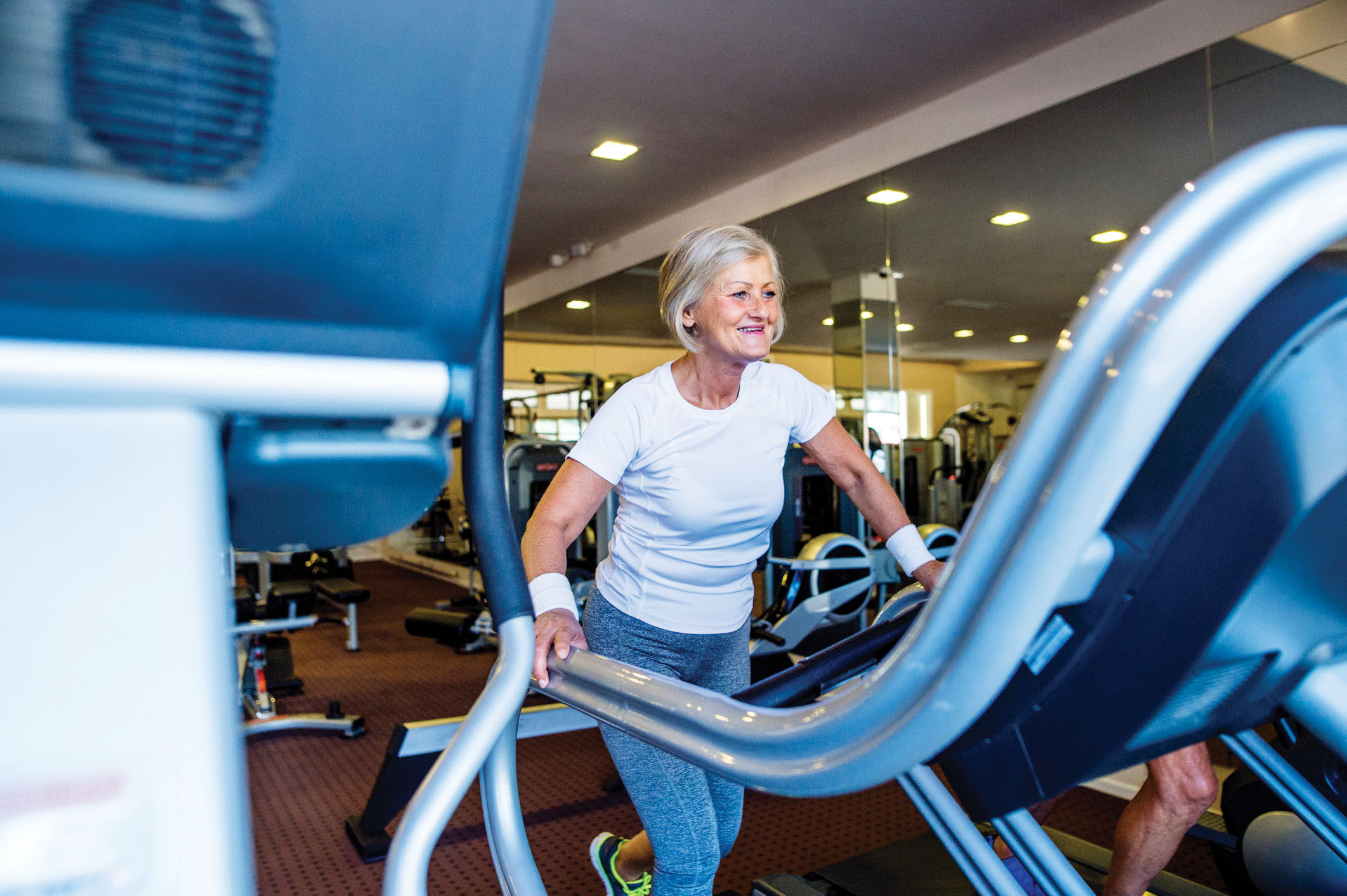 photo of a mature woman working out on a treadmill in a gym