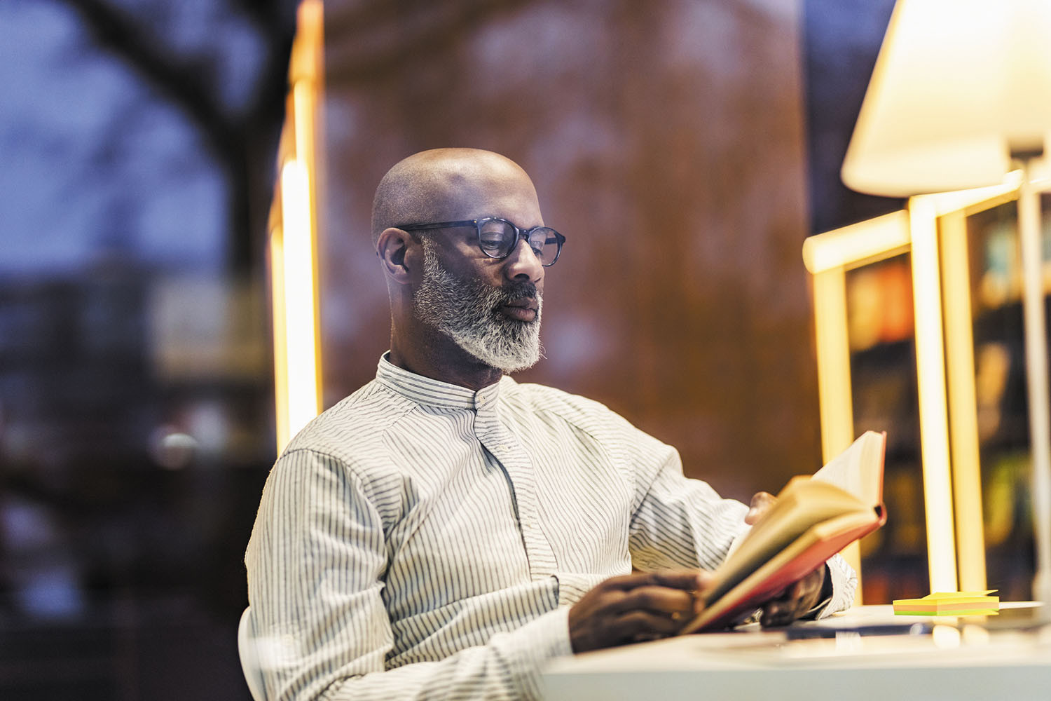 photo d'un homme lisant un livre assis à une table