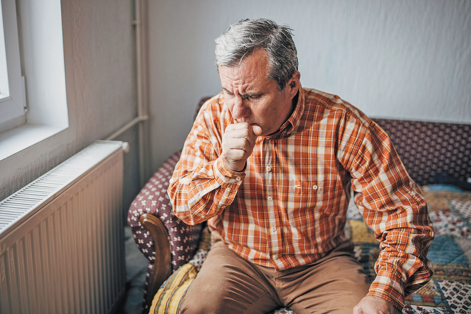photo of a mature man coughing