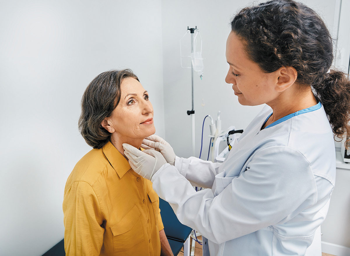 photo of a doctor examining a woman's neck