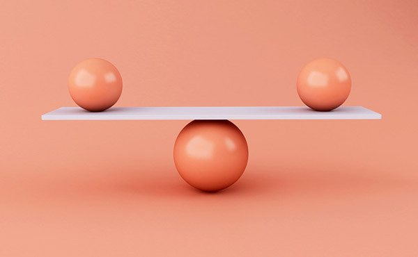 photo of two balls on either end on a white plank balanced on top of another ball