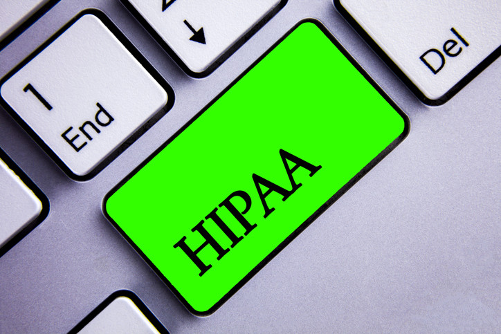 Part of computer keyboard with bright green key marked HIPAA