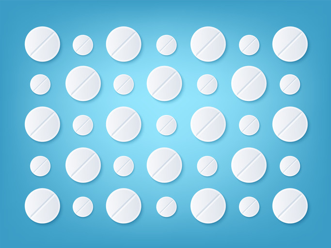Two rows of alternating white baby aspirin and white adult aspirin pills against a blue background 
