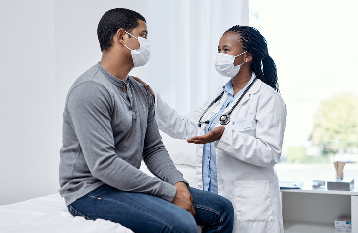 Doctor speaking with man at routine health visit