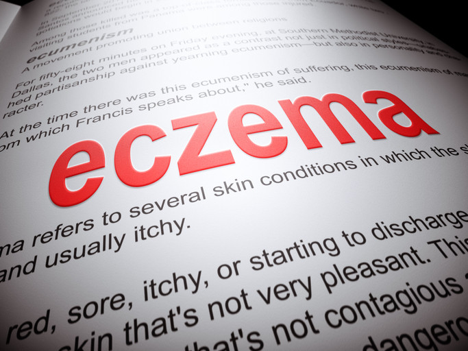 A partial dictionary definition of the word "eczema" typed in red that includes the words "sore, itchy"
