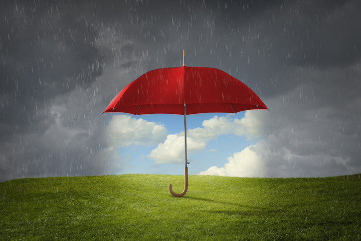 A red umbrella helps block rainy, stormy skies, opening up a patch of sunlight, blue skies, white clouds, and green grass