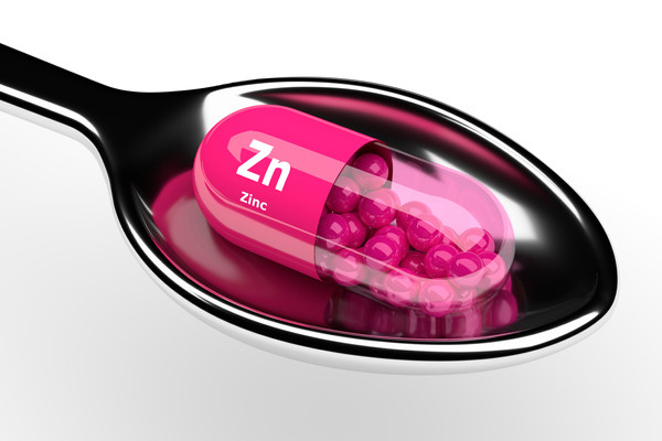 A single zinc pill on a spoon