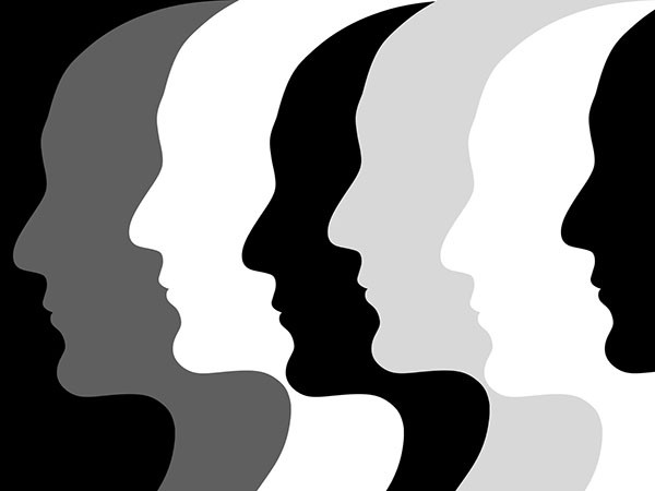 row of silhouette outlines of faces in profile in shades of black gray and white representing people of different races
