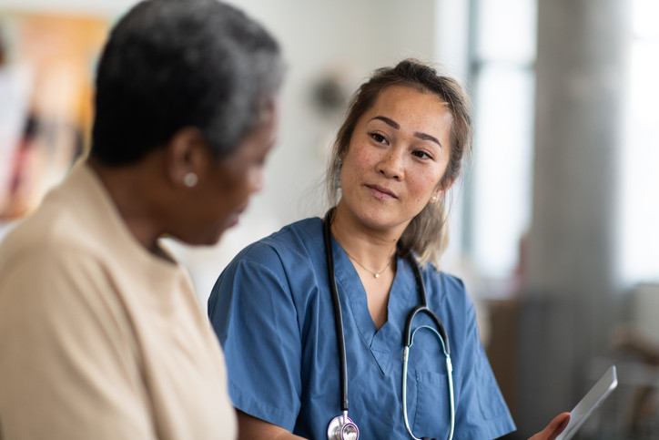 A doctor speaking with a patient as they sit side by side