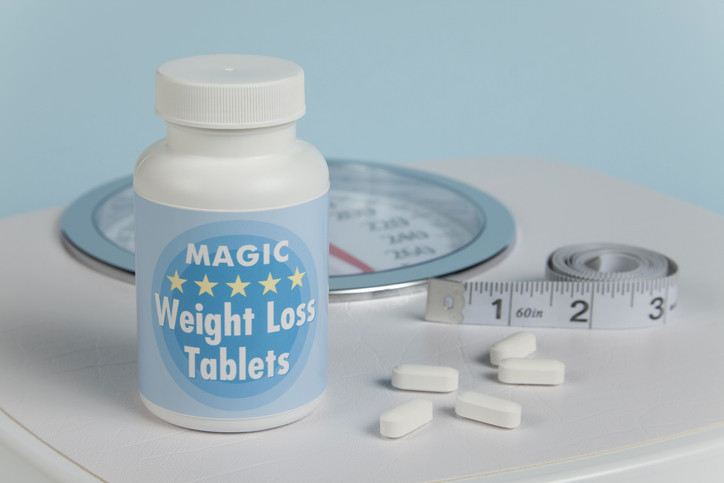 Photo of scale, Magic Weight Loss Tablets, tape measure and supplements