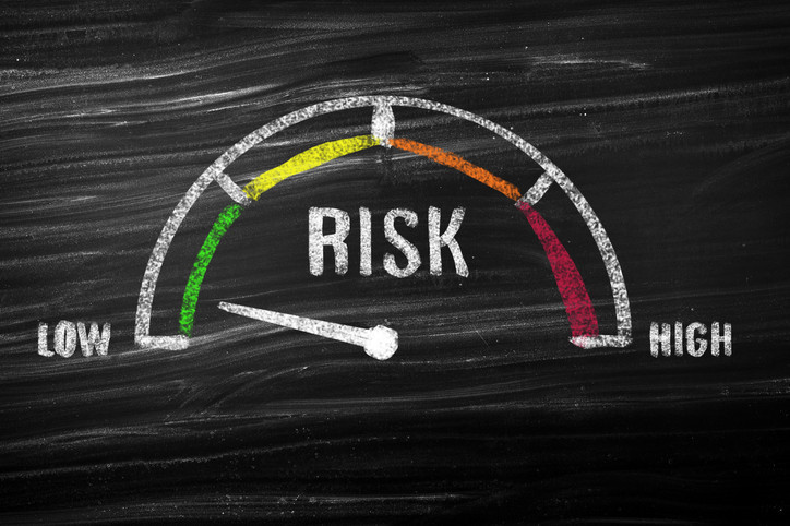 A meter to measure risk illustrated on a chalkboard, ranging from low to high