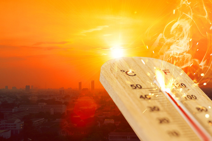 A thermometer reaching its upper limit and catching on fire, in the background the sky is dark orange indicating intense heat