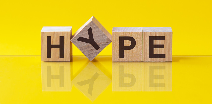 Hype spelled out on wooden blocks, Y tipped, yellow background and reflection