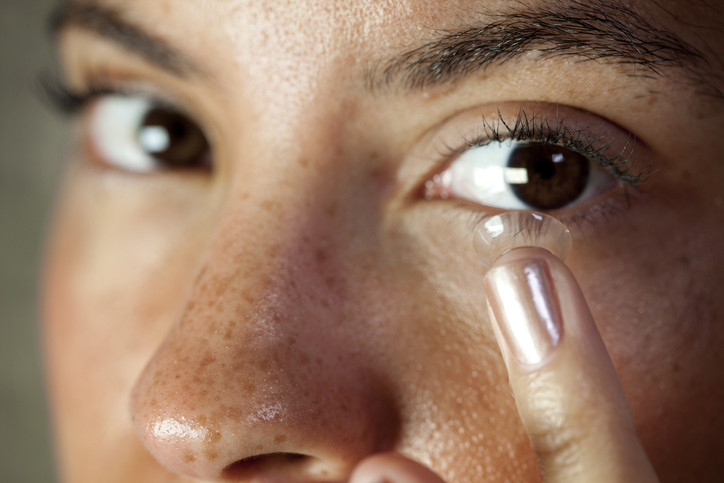 Woman putting contact lens in her eye