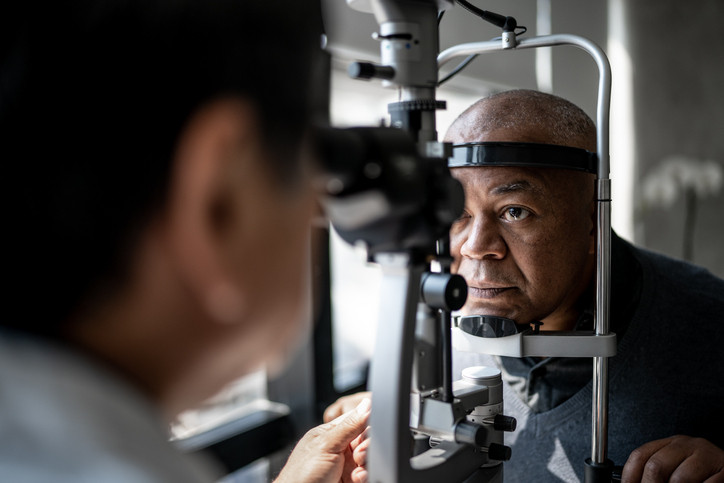 Ophthalmologist examining older man's eyes