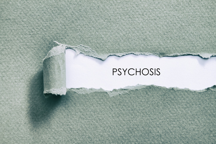 The word "psychosis" revealed under a peeled patch of blue-green textured paper
