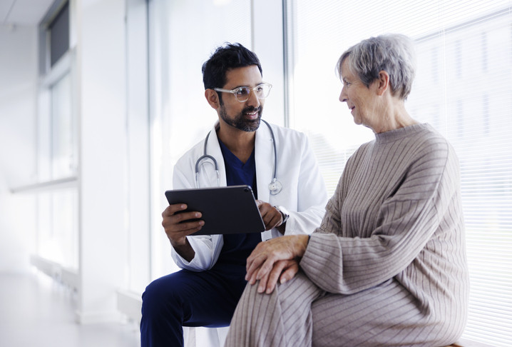 Photo of a woman at the doctor asking for a prescription. 