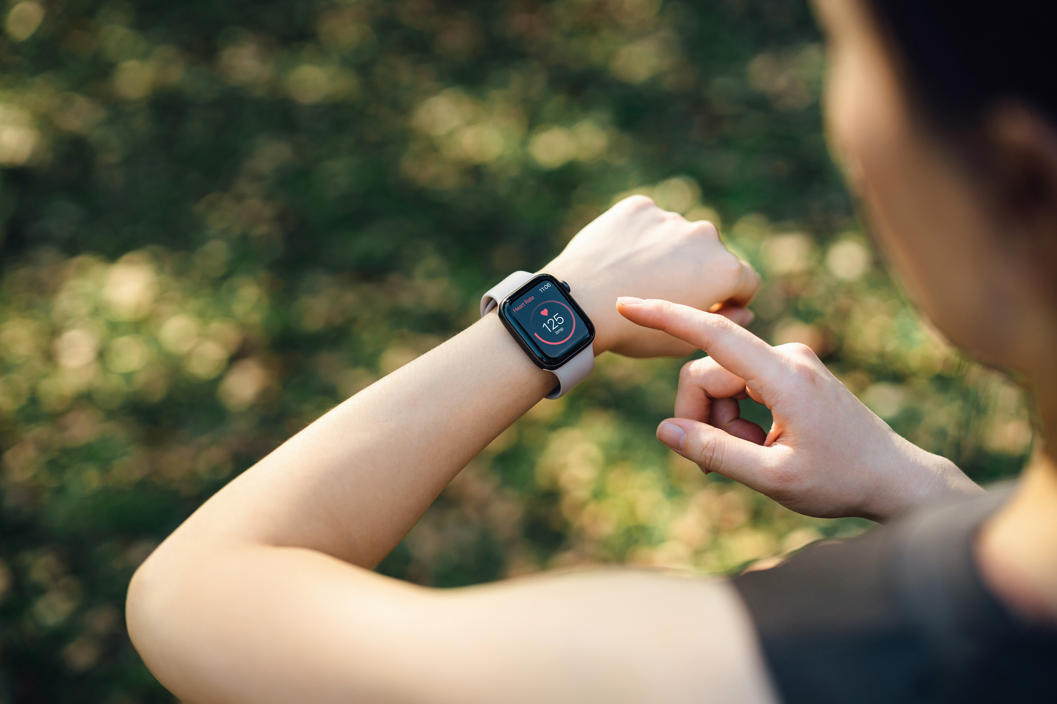 a woman checks her heart rate on a smart watch on her wrist