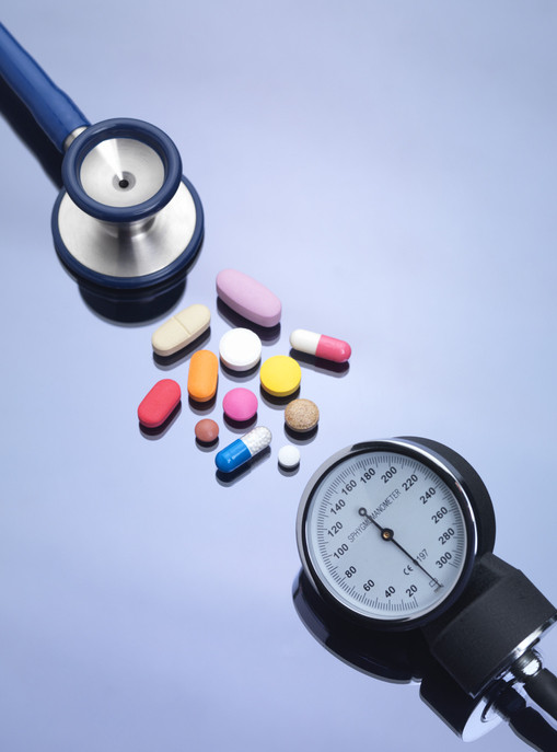 An assortment of pills next to a stethoscope. 