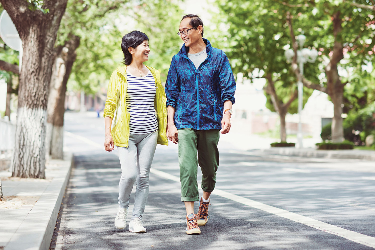 photo of a man and a woman walking outdoors and smiling at each other