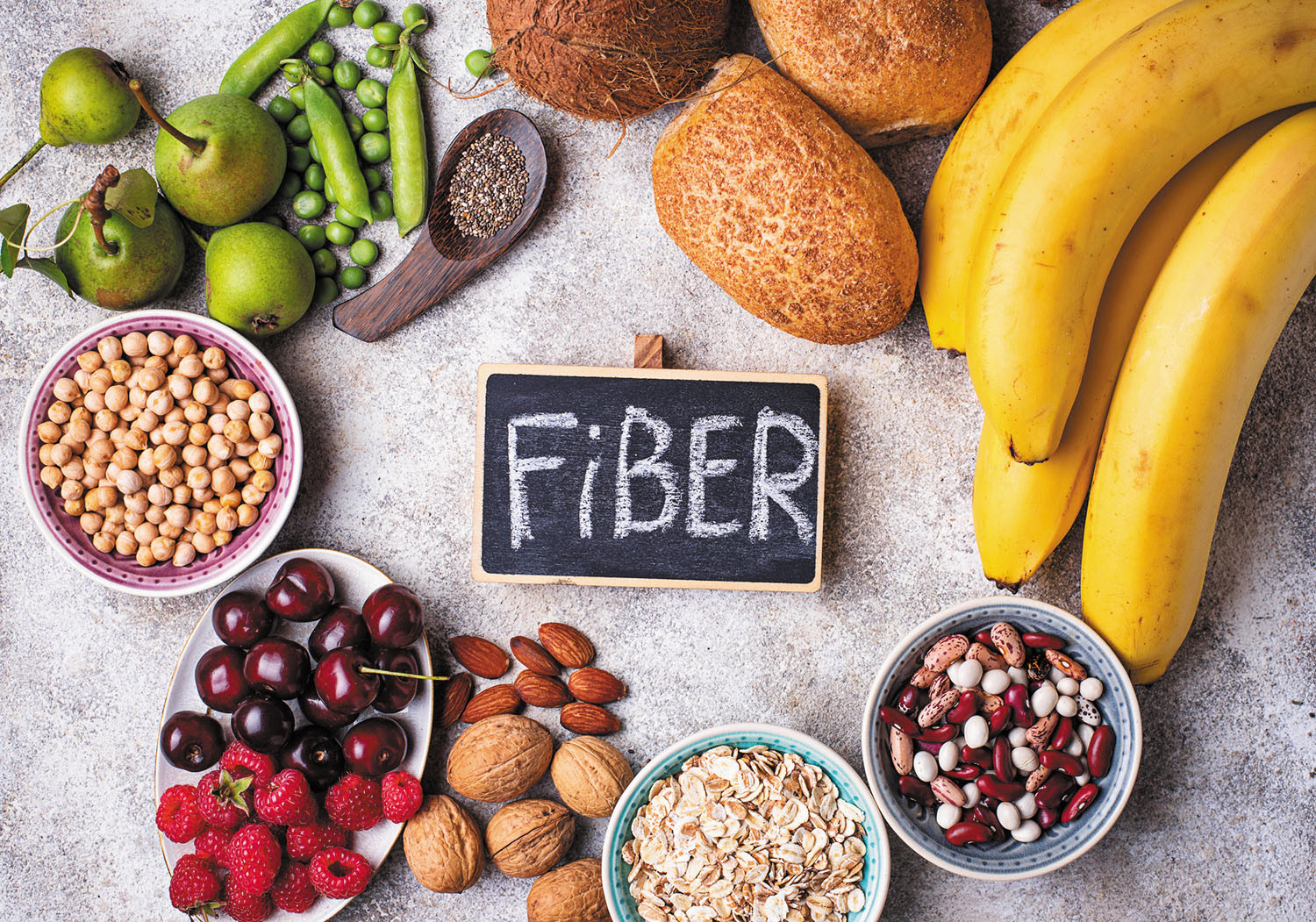 photo of an assortment of high-fiber foods with the word fiber in the center written on a small chalkboard