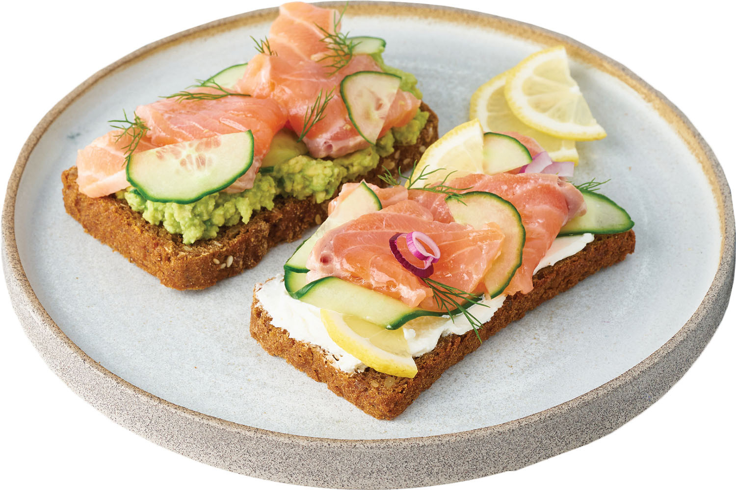 photo of a plate of toasted bread pieces layered with salmon, cucumber, and avocado