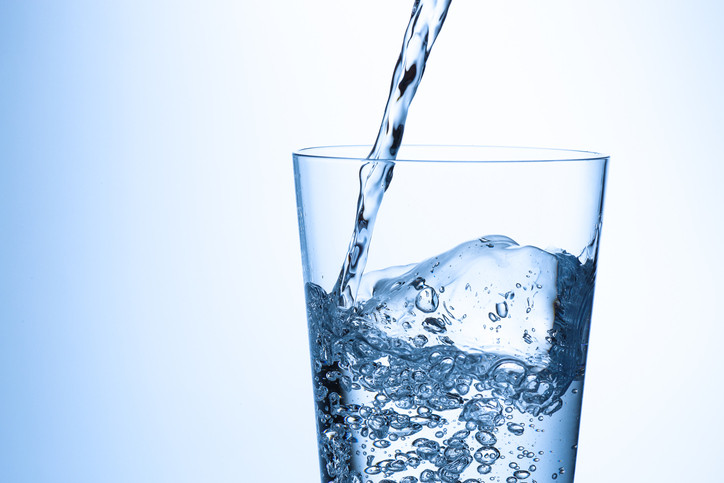 Water being poured into a tall glass. 