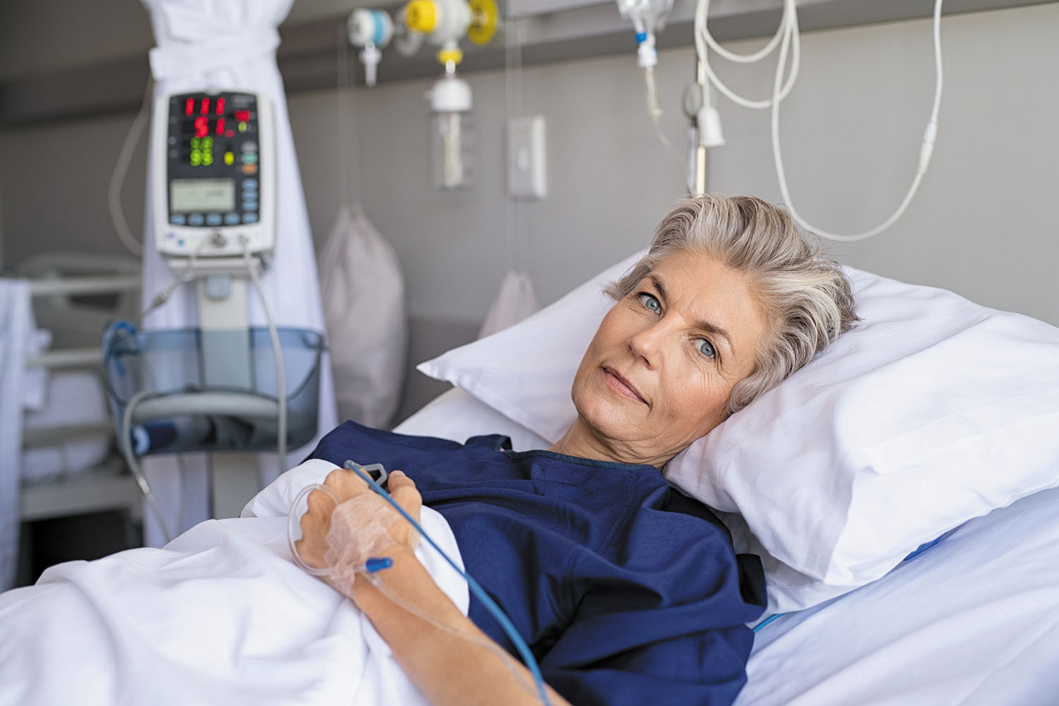 photo of a woman in a hospital bed, conscious and looking at the camera