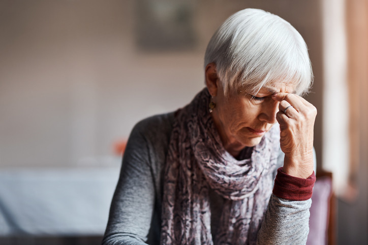 Shot of a senior woman experiencing a headache in a retirement home