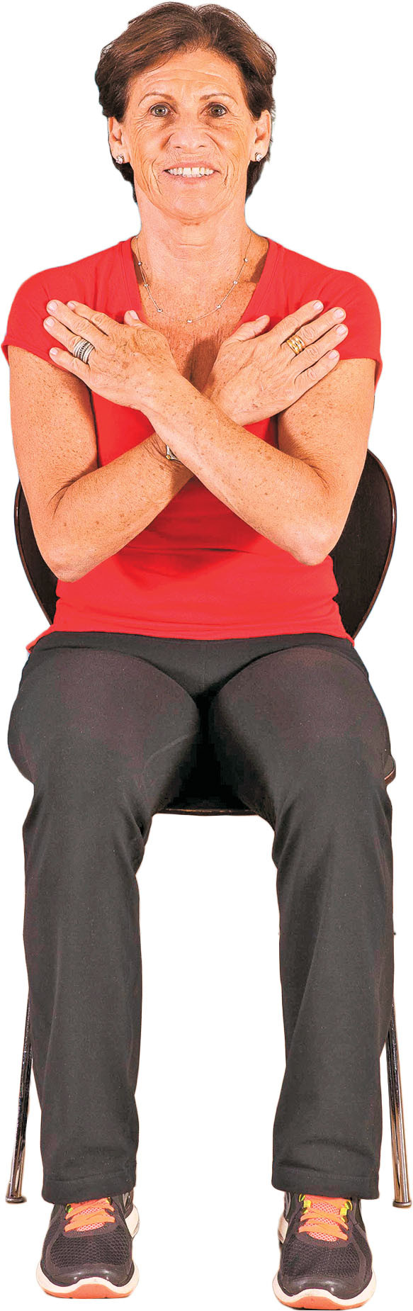 photo of a woman performing the sit-to-stand exercise step 1: sitting in a chair with her arms crossed over her chest