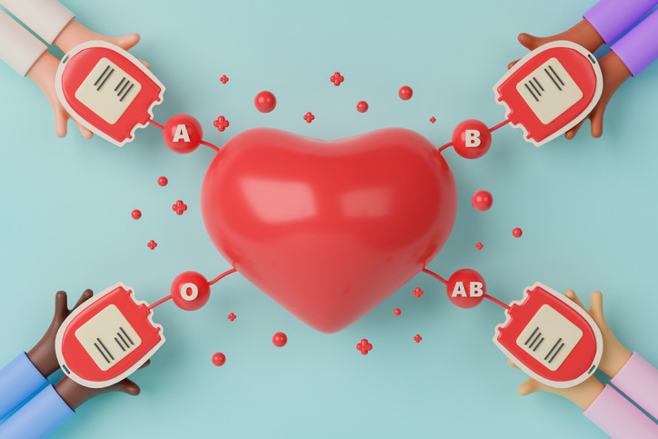 Cartoonish graphic with four pairs of hands holding blood donation bags; tubing marked with blood type leads to red heart in center 