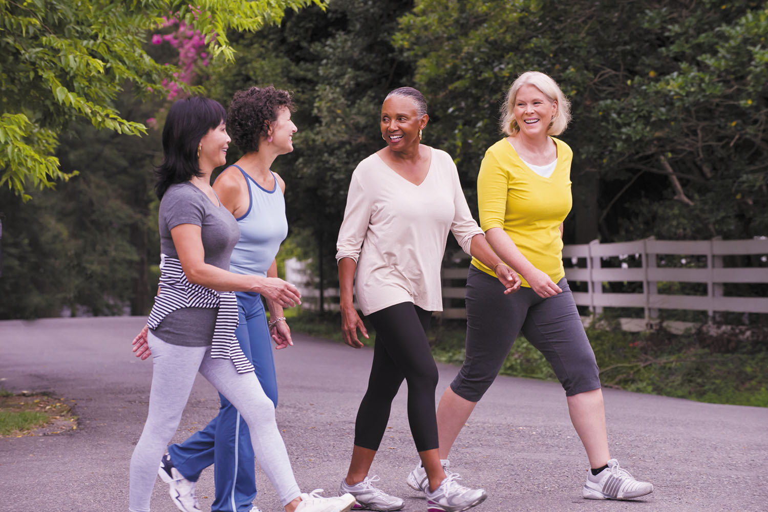 photo of a group of four women walking and talking in a park