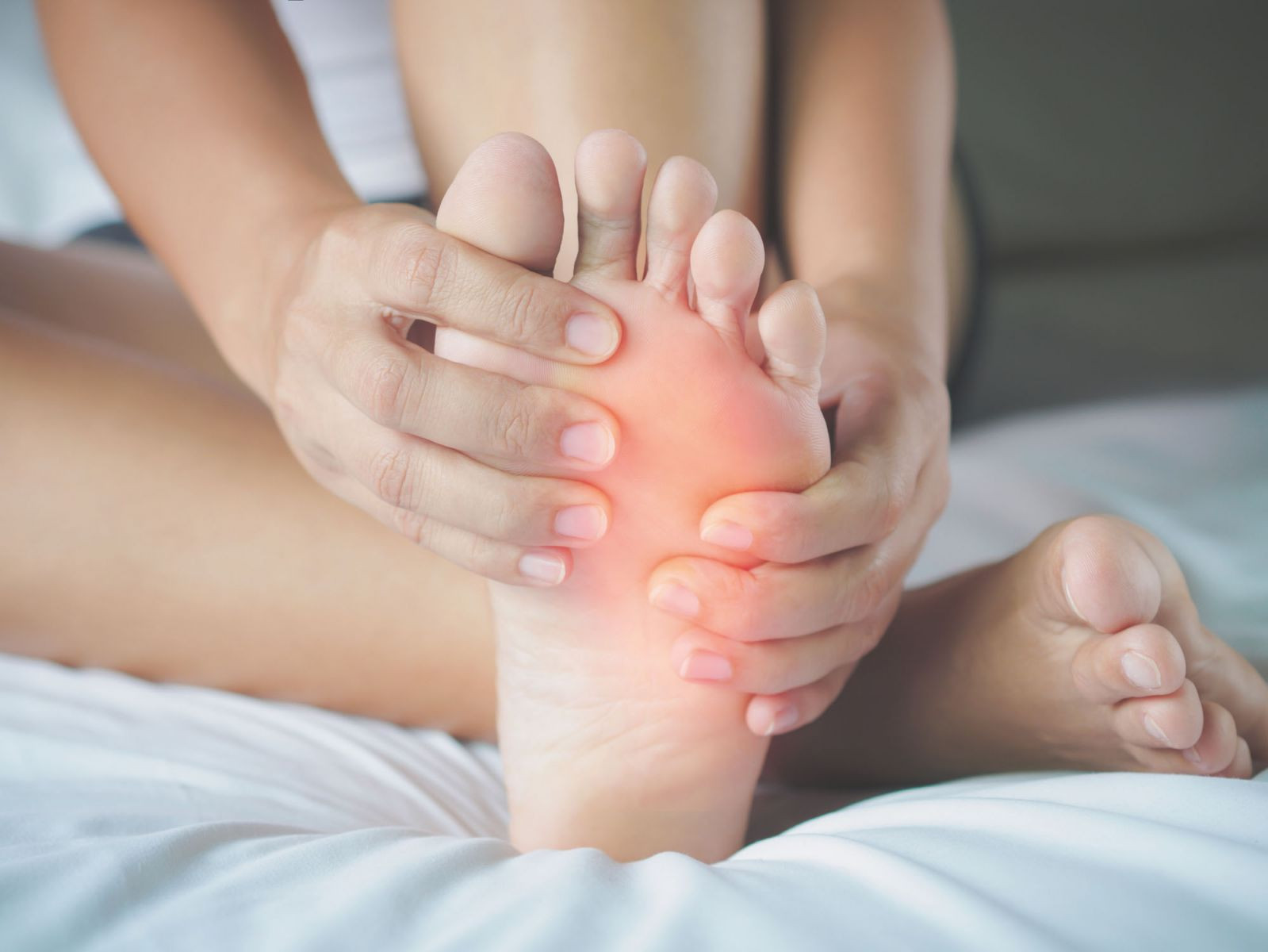 A woman holding her foot with both hands.