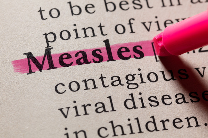 A dictionary page with the word measles highlighted in pink; the words contagious, viral disease, and in children appear below 