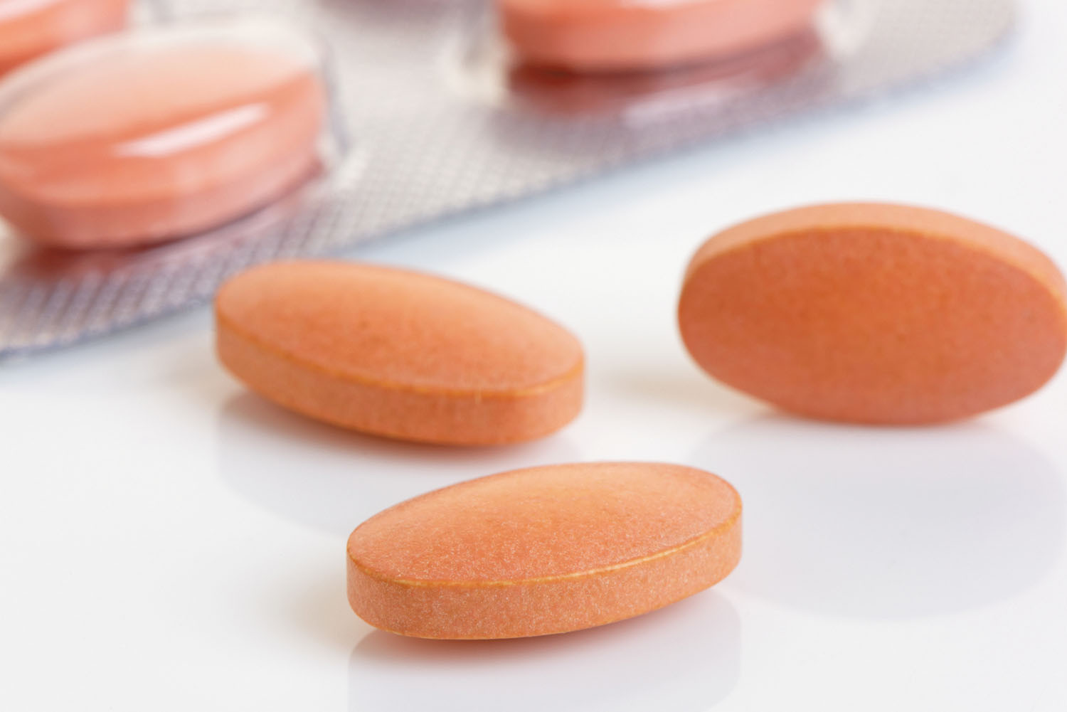 close-up photo of statin pills, some loose and some still inside blister packaging