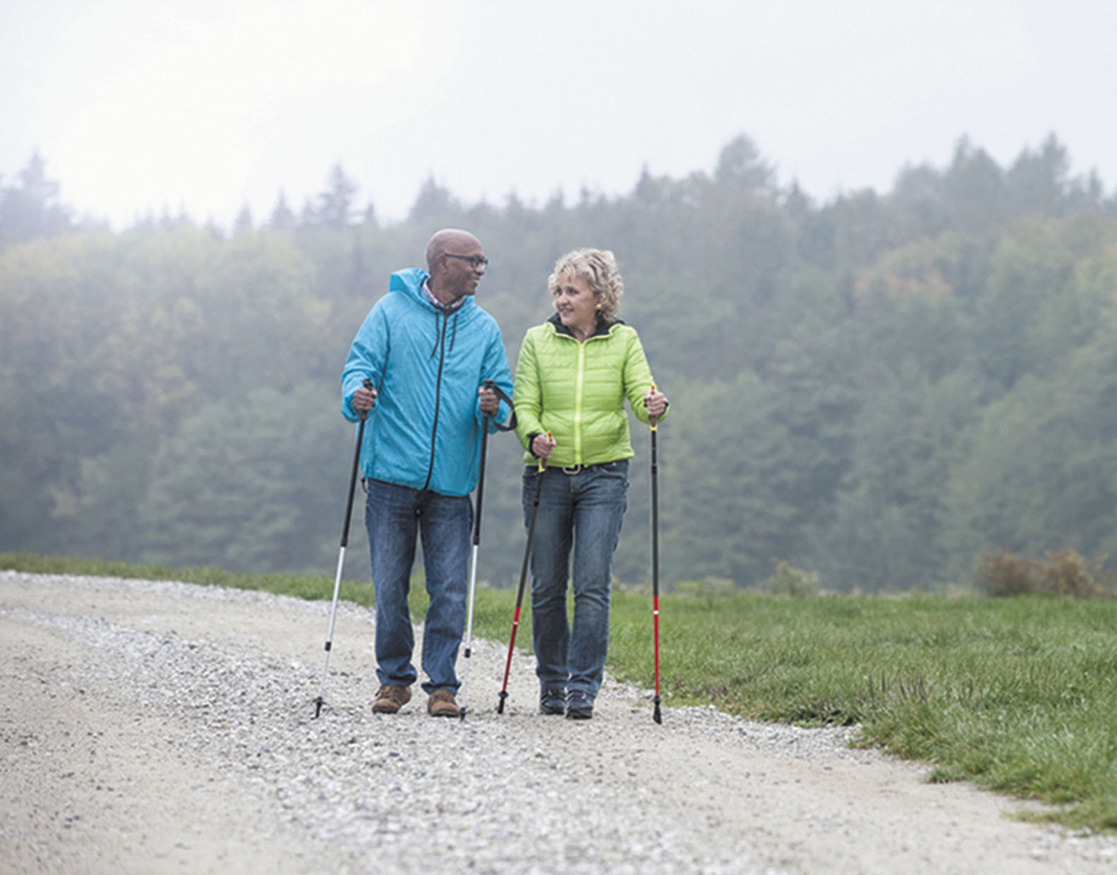 photo of a couple walking on a trail using poles for stability