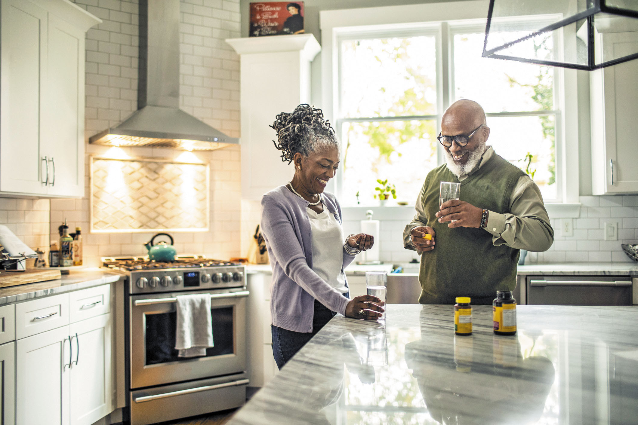 photo of a mature couple in their kitchen taking medications