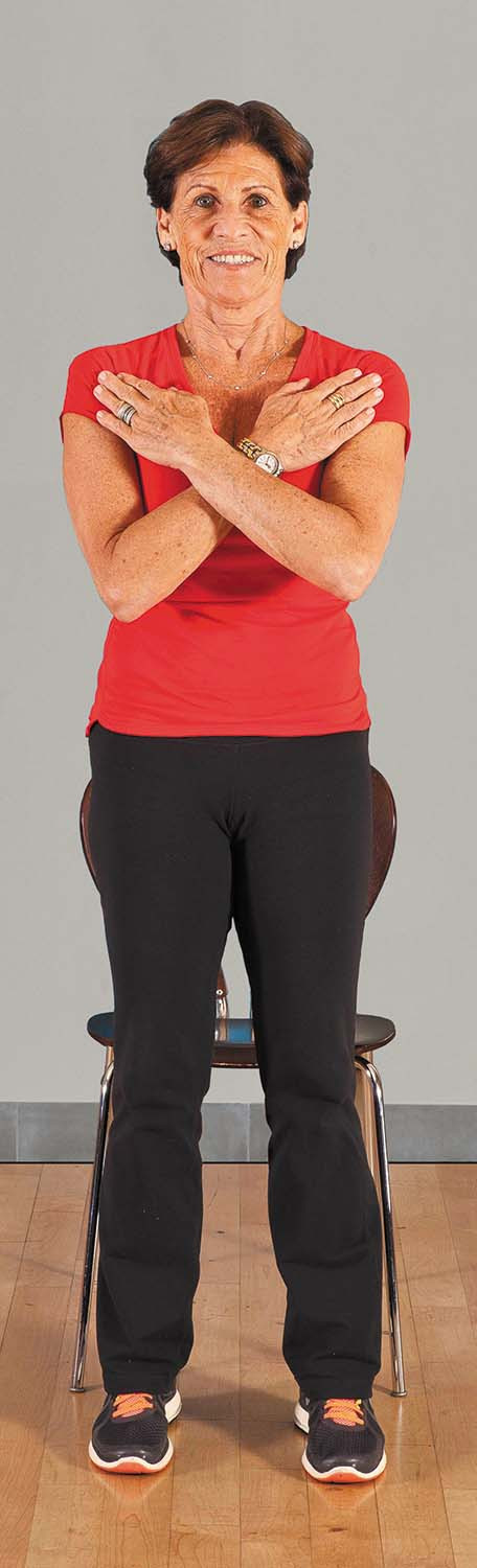photo of a woman performing the movement for the sit to stand (no hands) exercise as described in the article