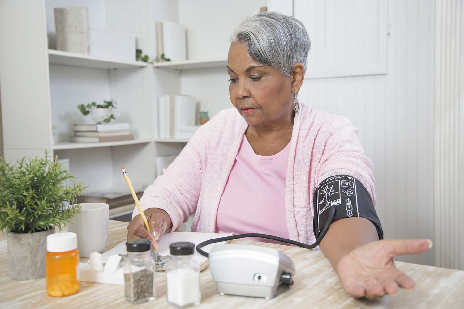 photo of a woman taking her blood pressure at home