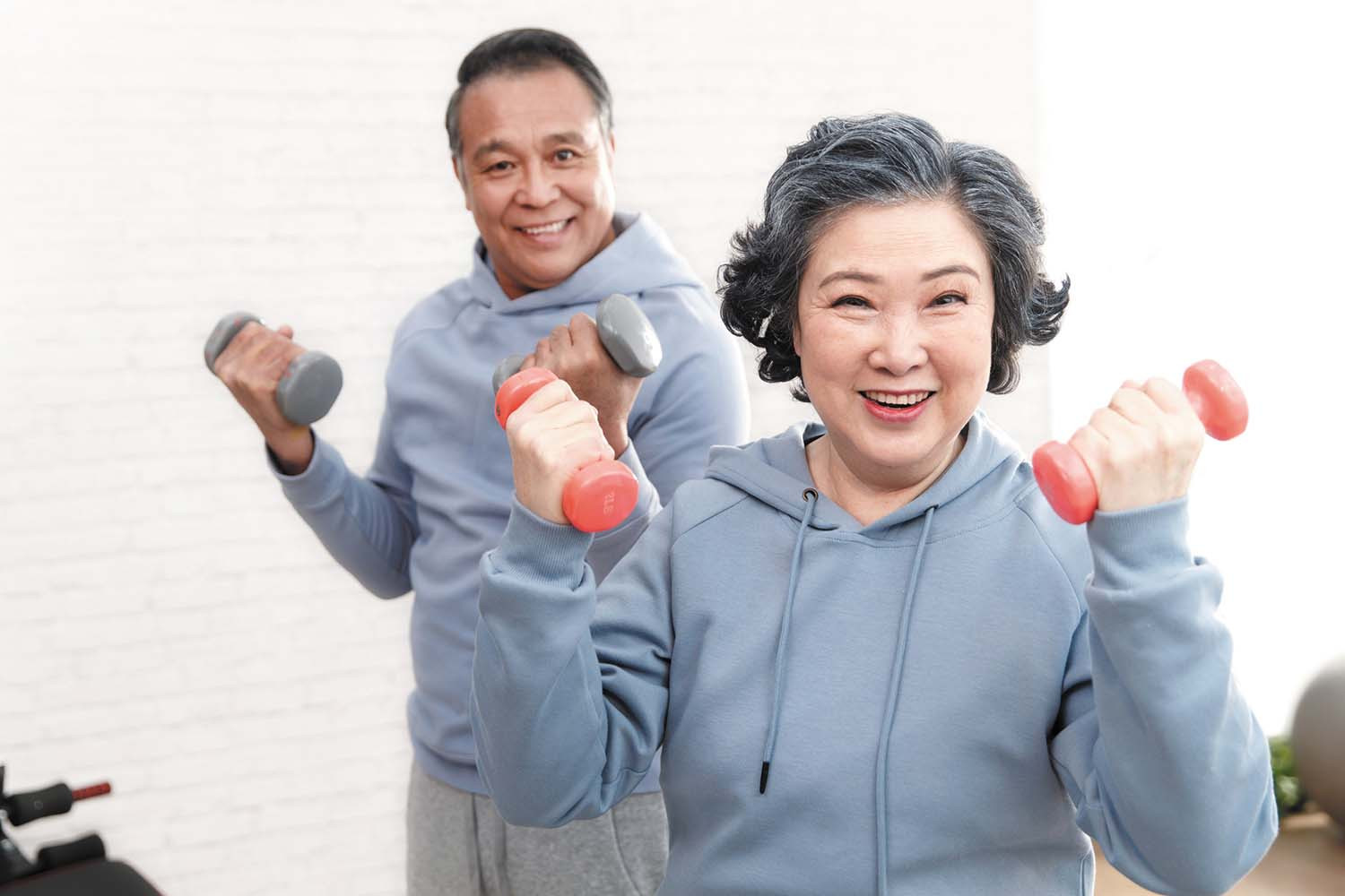 photo of a mature couple in workout clothing exercising using hand weights