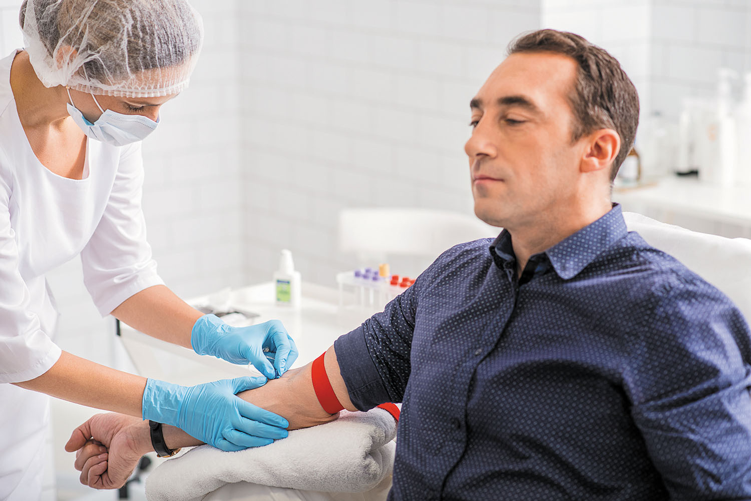 photo of a man trying to relax while having blood drawn for a lab test