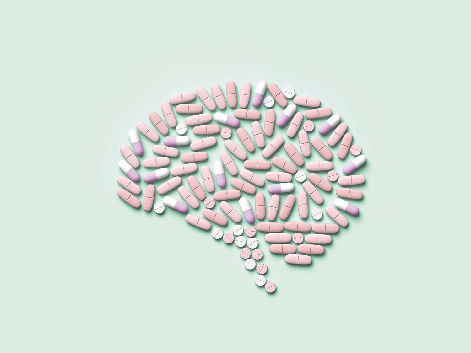 photo of an assortment of pills arranged into the shape of a human brain, on a light green background