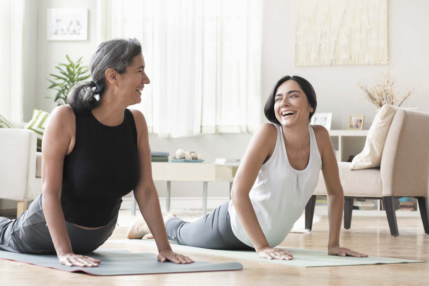 photo of two women doing yoga in a home