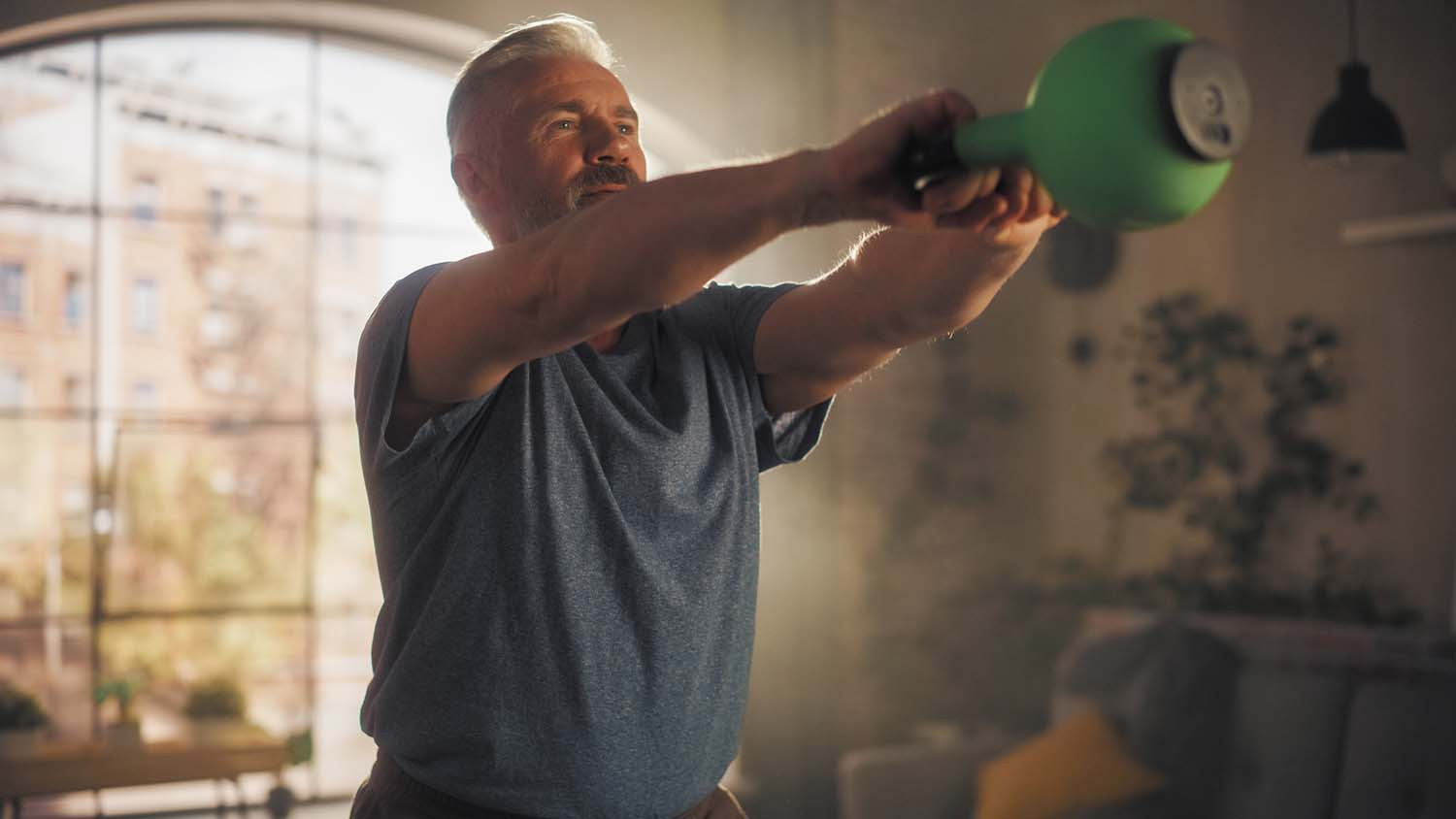 photo of a man exercising with a kettlebell in his home